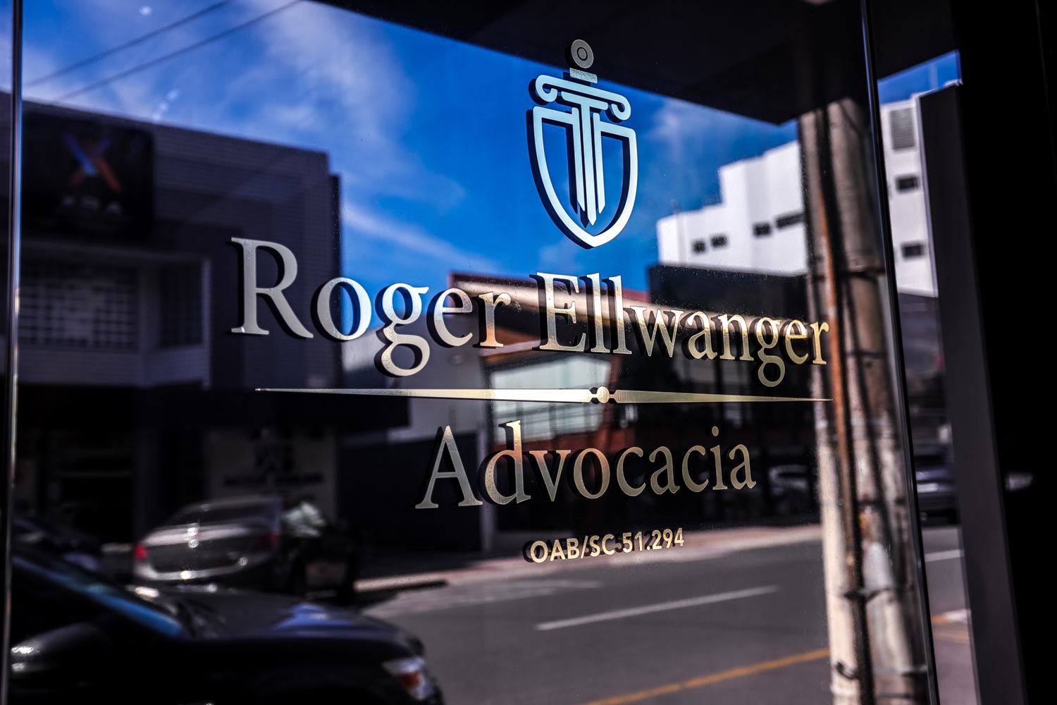 Letreiro dourado Roger Ellwanger Advocacia na porta de vidro do escritório